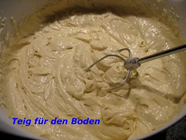 Ein cremiger Teig für einen Apfelkuchen mit Dinkelmehl wird in einer Rührschüssel zubereitet.