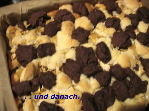 Ein frisch gebackener Apfelkuchen mit Dinkelmehl ist mit marmorierten Streuseln dekoriert, der in einer Backform liegt.