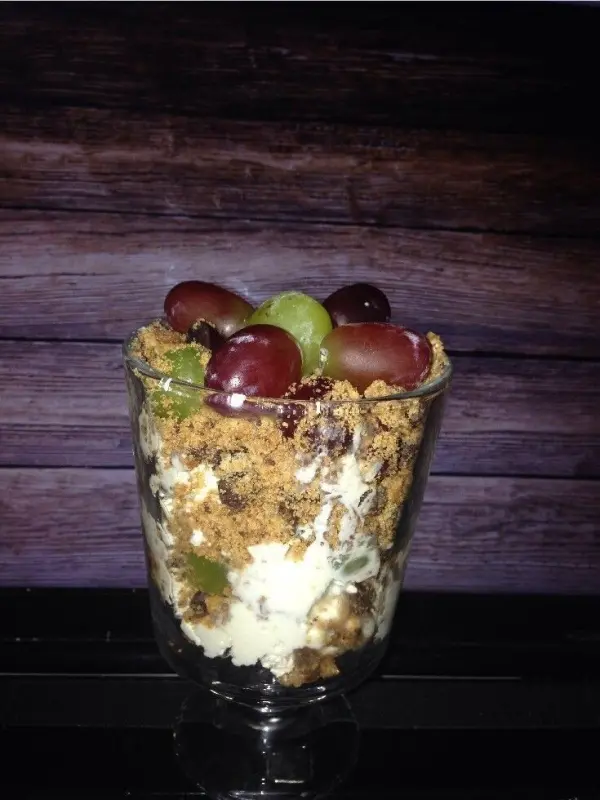 Ein Glas voller Weintrauben-Cookies-Nachtisch kombiniert frische Trauben, zerbröselte Kekse und eine cremige Schicht.