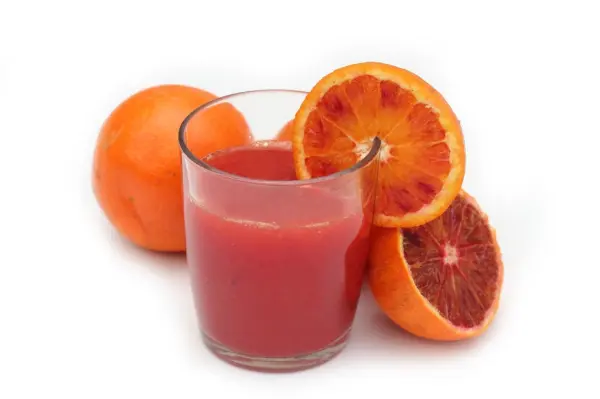 Ein Glas Blutorangengelee ist gefüllt mit frisch gepresstem, leuchtend rotem Saft, umgeben von ganzen und aufgeschnittenen Blutorangen.