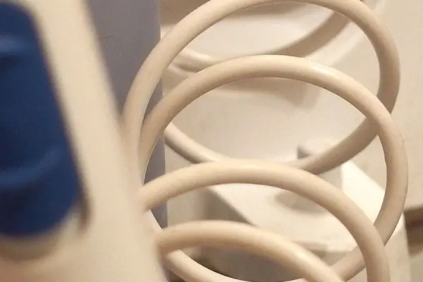 Eine Munddusche zeigt eine gewundene Schlauchleitung, die für die Wasserzufuhr in einem Badezimmer gedacht ist.