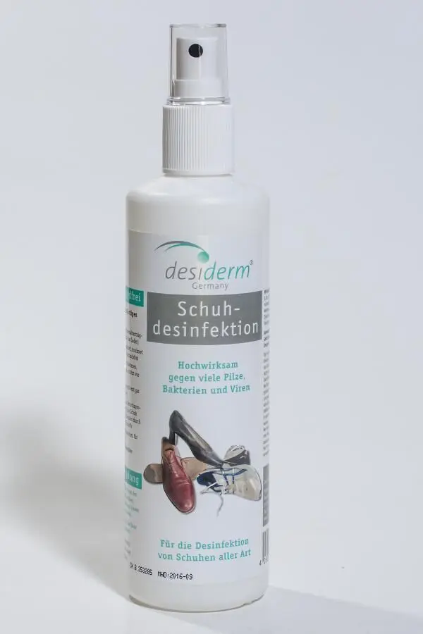 Eine Flasche Schuhdesinfektionsspray steht auf einem hellen Hintergrund und bietet eine Lösung gegen stinkende Füße.