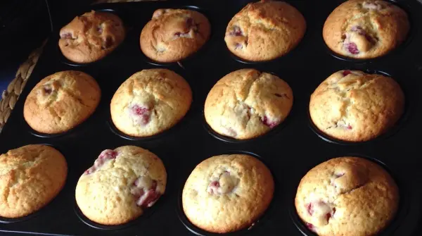 Leckere Himbeer-Limetten Muffins stehen frisch gebacken in einem Muffinblech, perfekt für einen süßen Snack.