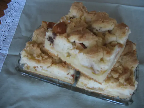 Schneller Apfelkuchen mit goldenen Butterstreuseln liegt in einem Glas auf grünem Tuch, bereit zum Servieren.