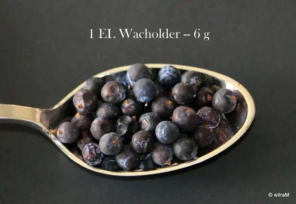 Ein Esslöffel mit Heidelbeeren zeigt die Mengenabmessung ohne Waage, auf schwarzem Hintergrund.