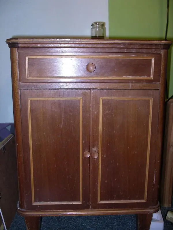 Ein Holzmöbelstück steht in einem Raum und wartet darauf, mit Essig-Öl poliert zu werden, um seinen Glanz zu erneuern.