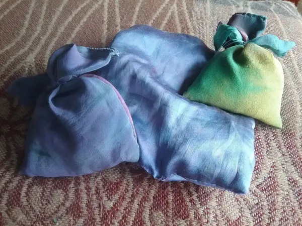 Bunte Duftsäckchen aus Lavendel liegen auf einem gemusterten Untergrund und verbreiten angenehmen Duft.