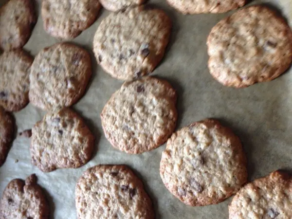 Kekse aus Müsliresten liegen auf einem Backblech, frisch gebacken und leicht gebräunt, bereit zum Genießen.