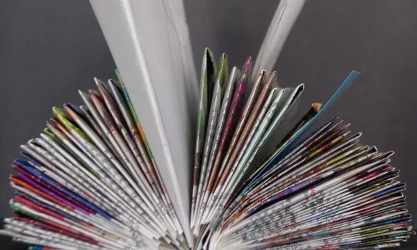 Ein aufgeschlagenes Katalogbuch steht offen, während bunte Seiten in einer kreativen Anordnung nach außen zeigen.