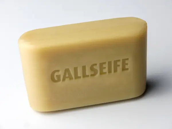 Ein Stück Gallseife liegt auf einer neutralen Oberfläche und zeigt deutlich die eingestempelte Schrift "GALLSEIFE".