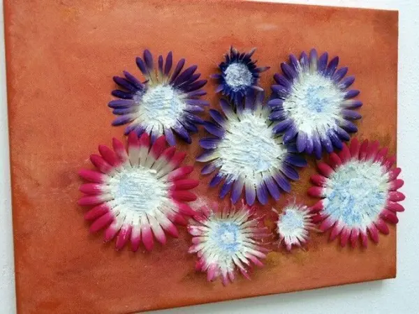 Farbenfrohe Plastikblumen formen ein Acrylbild, das lebendige Blüten auf einem orangefarbenen Hintergrund zeigt.
