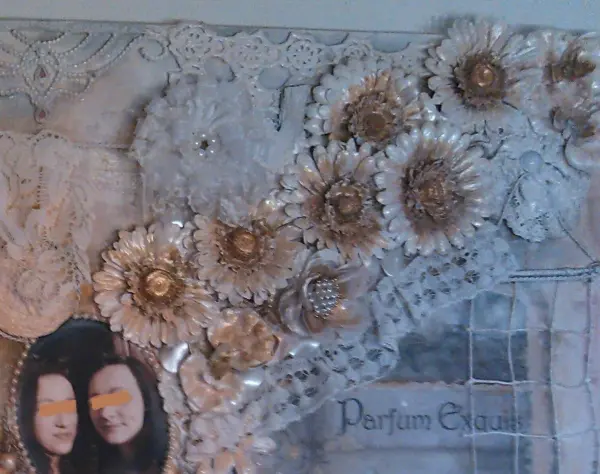 Acrylbild zeigt weiße Plastikblütenblätter auf Spitze mit Text "Parfum Exquis". Darunter ein Foto von zwei Frauen.