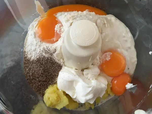 Ein Mixbehälter enthält Eier, Mehl, Zuckermasse und andere Zutaten für den Russischen Schokoladenzopf.