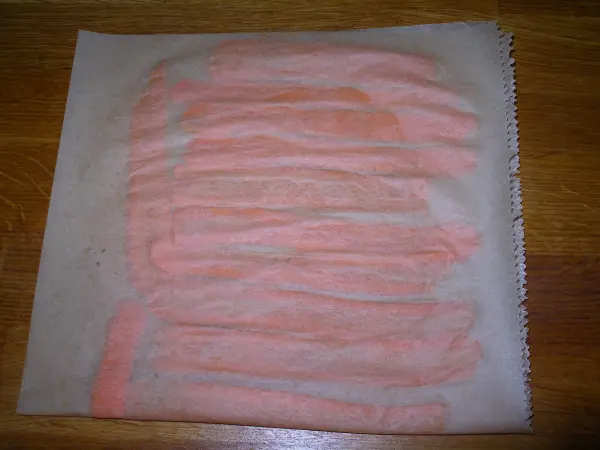 Möhrenchips liegen auf einem Backblech mit Backpapier, während sie darauf vorbereitet werden, in einem heißen Bügeleisen gegart zu werden.