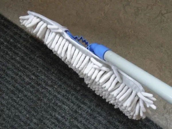 Ein Wischmopp liegt auf einem Teppich und bereit, den Boden zu reinigen und für einen sauberen, glatten Boden zu sorgen.