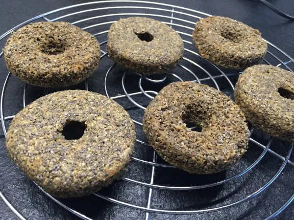 Sechs Chia Donuts liegen auf einem Kuchengitter, frisch zubereitet und bereit zum Dekorieren mit Zitronen-Kokos-Creme.