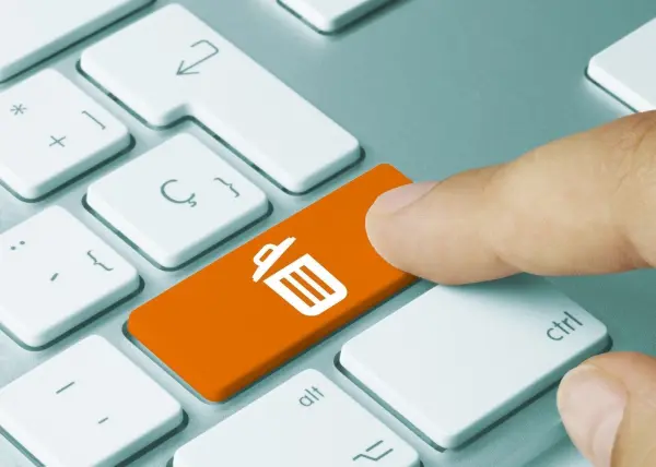 Eine Hand drückt die Löschtaste auf einer Computer-tastatur, um digitale Dateien im Rahmen des digitalen Frühjahrsputzes zu entfernen.