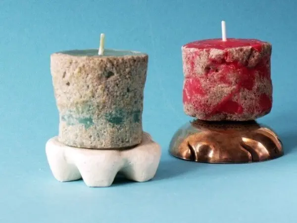 Bunte Sandkerzen stehen auf einem hellen Untergrund, während sie fröhlich im Licht leuchten und für Stimmung sorgen.
