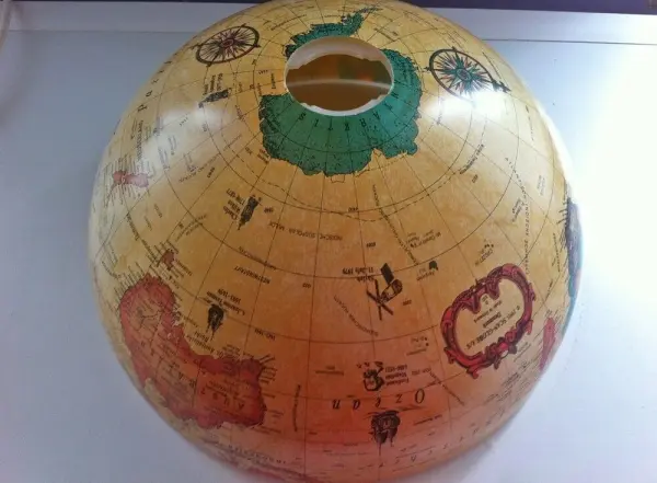 Ein alter Globus wurde in eine Schale umgewandelt und steht auf einem weißen Tisch, bereit für die Nutzung in einem kreativen Kontext.