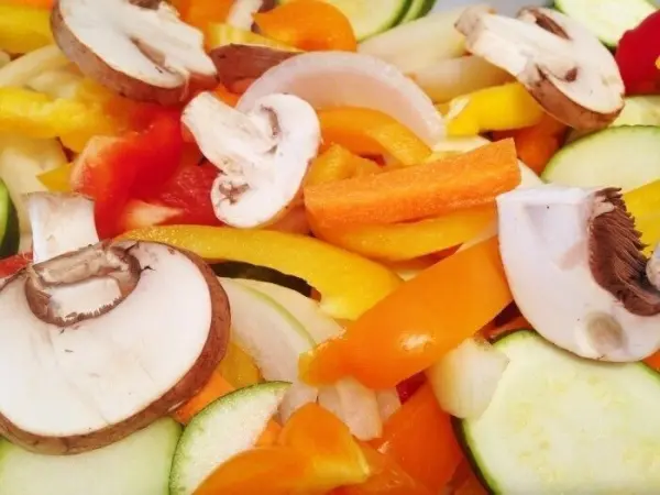 Bunte Ofengemüse-Mischung aus Zucchini, Paprika und Champignons, frisch geschnitten für die Zubereitung.