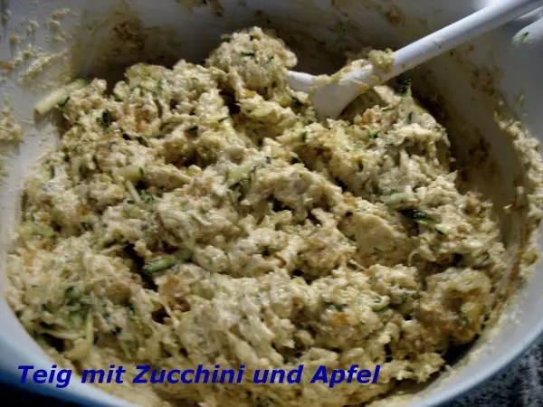 Der teigige Zucchini-Apfel-Mix wird mit einem Löffel in einer Schüssel vorbereitet, um leckere Cookies zu backen.
