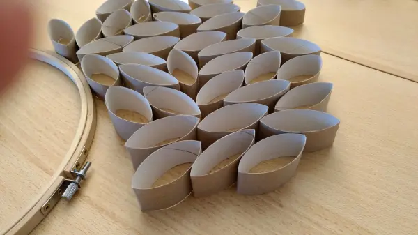 Ein runder Osterkranz besteht aus gefalteten Papierformen, die sorgfältig auf einem Tisch angeordnet sind.
