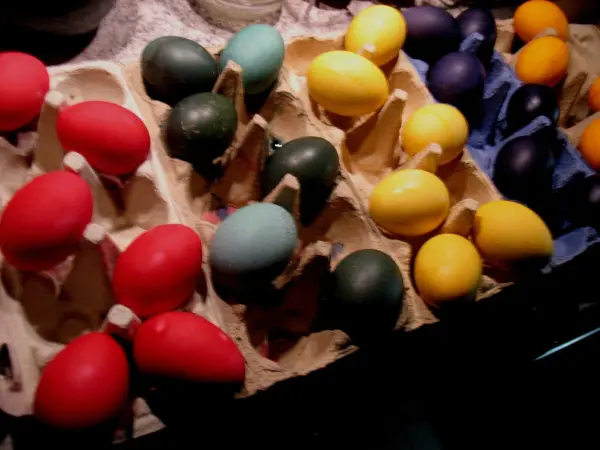 Bunte Ostereier liegen in einem Karton, hell beleuchtet, bereit zum Dekorieren für das Osterfest.
