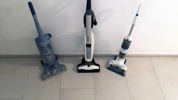Drei Hartbodenreiniger stehen auf einem hellen Fliesenboden, bereit zum Testen in einem modernen Raum.