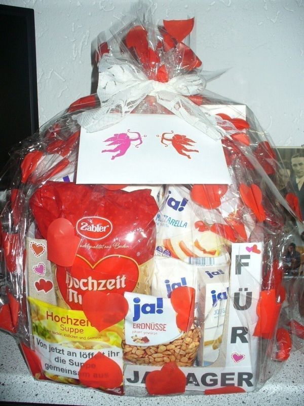 Ein liebevoll dekorierter Geschenkkorb mit roten Herzen und Snacks, um das Hochzeitsmotiv "Für Ja-Sager" zu feiern.