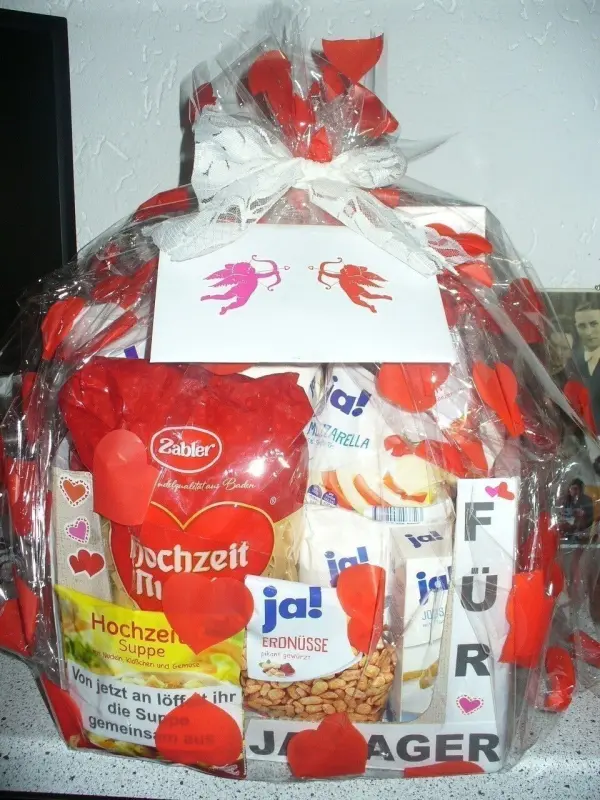 Ein liebevoll dekorierter Geschenkkorb mit roten Herzen und Snacks, um das Hochzeitsmotiv "Für Ja-Sager" zu feiern.