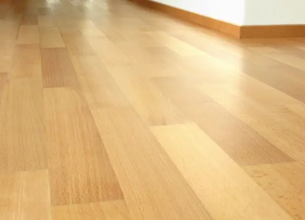 Ein Laminatboden erstreckt sich über den gesamten Raum, in dem das Teppichklebeband entfernt wurde.