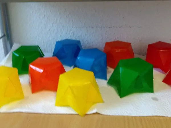 Bunte Papier-Windlichter stehen auf einem Tisch, bereit zum Basteln im adventlichen Umfeld.