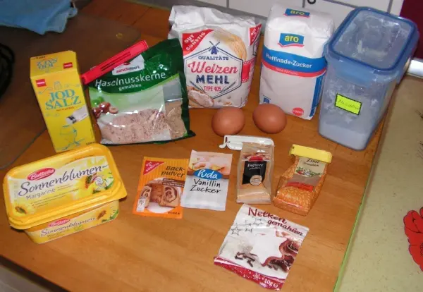 Zutaten für Weihnachtskekse liegen auf einem Tisch. Eier, Mehl und Zucker sind bereit für das Backen in der Küche.