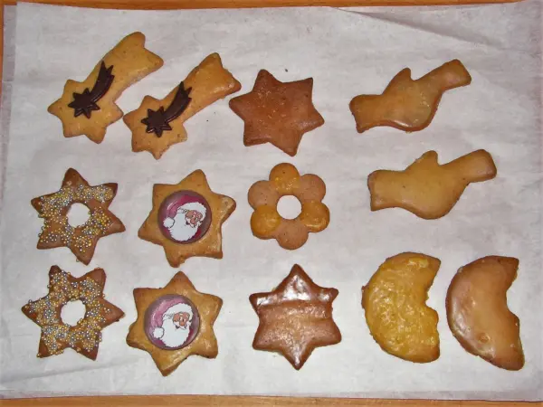 Auf einem blech liegen frisch gebackene Weihnachtskekse in verschiedenen Formen, bereit zum Genießen und Verzieren.