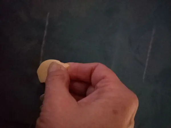Eine Hand hält ein Stück Seifenrest und reibt es an einer Oberfläche, um es weiterzuverwenden.