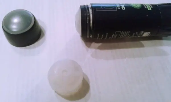 Ein Deostick liegt auf einer Fläche, während er geöffnet wird, um den Inhalt restlos zu verwenden und Geld zu sparen.