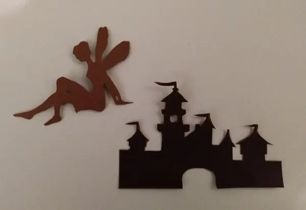 Ein durchsichtiges Windlicht zeigt eine feenartige Figur und ein Schloss, die zusammen in kreativem Bastelkontext platziert sind.