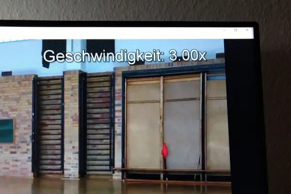 Ein Video wird mit einer Geschwindigkeit von 3,00x abgespielt, während sich ein roter Gegenstand vor einer Wand bewegt.