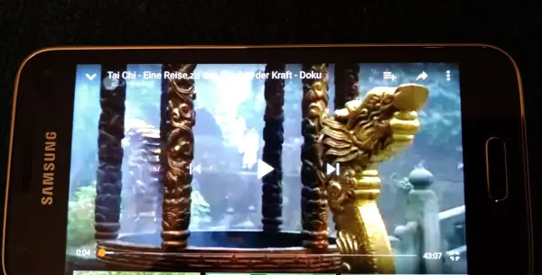 Ein Smartphone zeigt ein Video an, das langsamer abgespielt wird, während sich majestätische Szenen im Hintergrund entfalten.