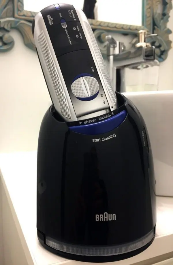 Ein Rasierer steht in einer schwarzen Reinigungskartusche und wird gereinigt, um maximale Hygiene und Effizienz zu gewährleisten.