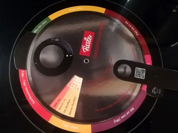 Ein kochender Topf mit einem transparenten Deckel zeigt den Kochvorgang für getrocknete Bohnen, dicht auf einem Herd platziert.