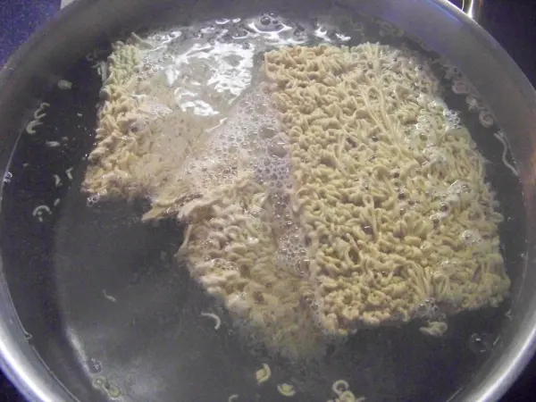 In einem Topf kochen zwei Blöcke von Jiachang Doufu in sprudelndem Wasser, um sie zuzubereiten.