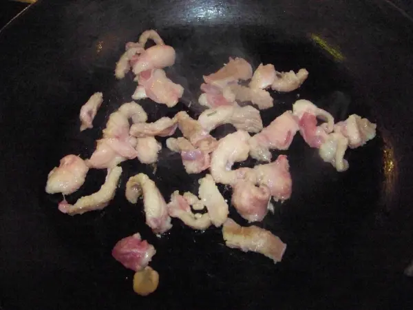 In einer Pfanne braten kleine Stücke von Entenbrust, die goldbraun werden, während sie in Fett sizzeln.