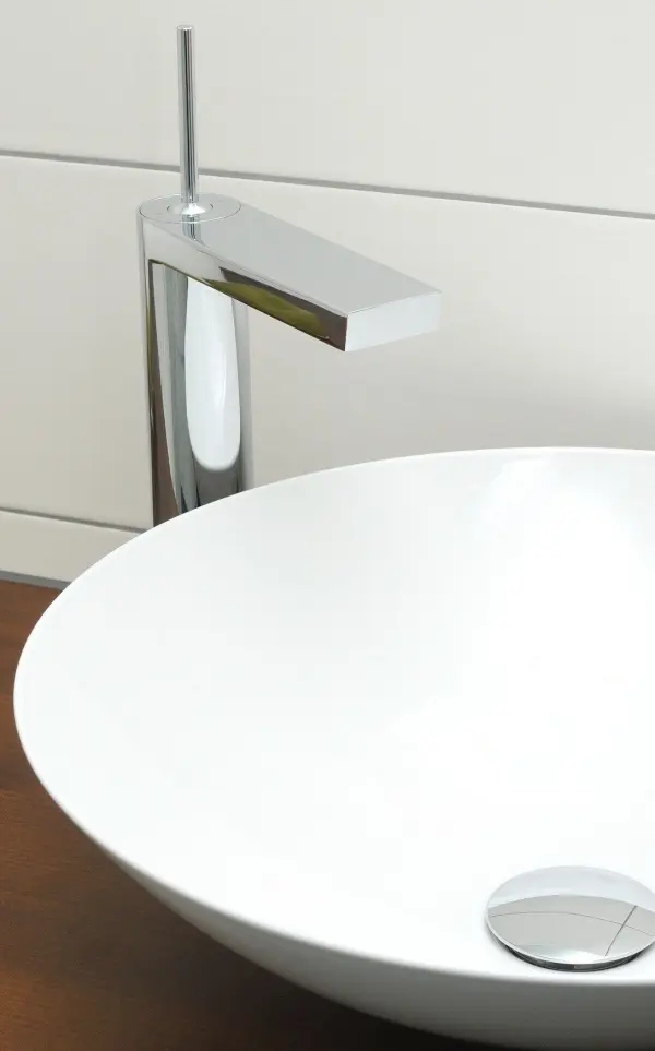 Ein modernes Waschbecken mit einer glänzenden Armatur steht auf einer Holzoberfläche, bereit zur Nutzung in einem eleganten Badezimmer.