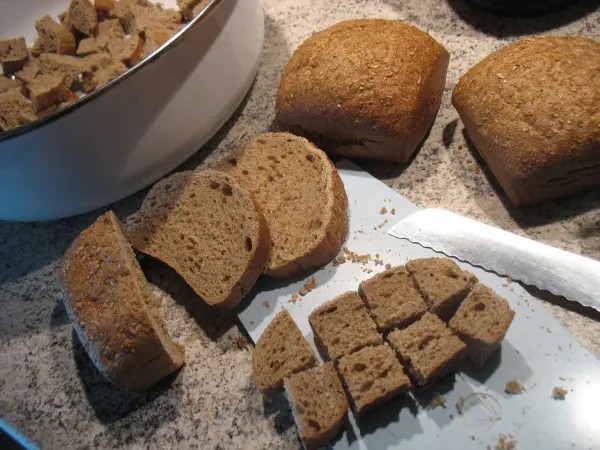 Eine frisch geschnittene Brotsorte liegt auf einem Schneidebrett, während es Stücke für die Milchkaltschale dient.