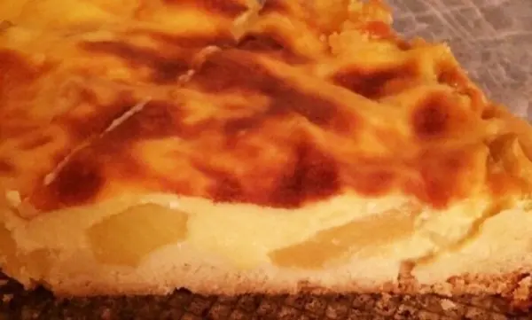 Ein goldbraun gebackener Apfelkuchen mit Guss liegt auf einem Kuchengitter und verströmt einen köstlichen Duft.