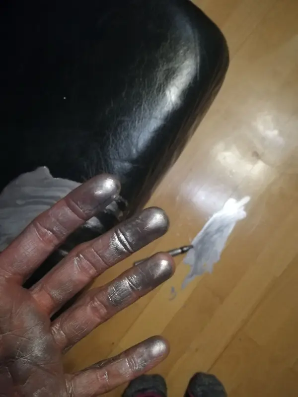 Eine hand mit Edding-Flecken zeigt die Auswirkungen beim Entfernen von Edding von Parkett und Leder im Wohnraum.