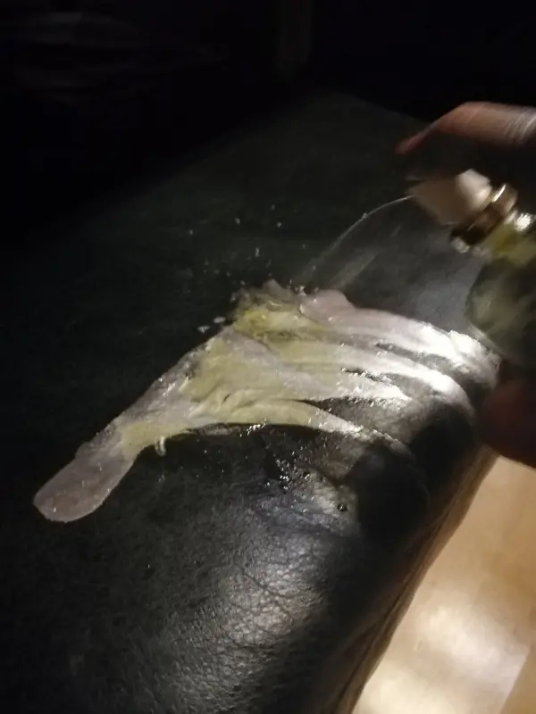 Ein Reinigungsmittel wird auf eine ledere Oberfläche aufgetragen, um Edding-Rückstände zu entfernen.