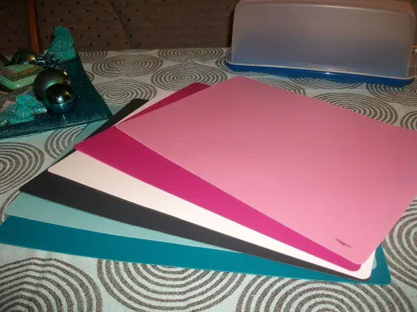 Bunte Unterlagen liegen auf einem Tisch, ideal zum Schutz von Tortenbehältern vor Kratzern bei der Lagerung.
