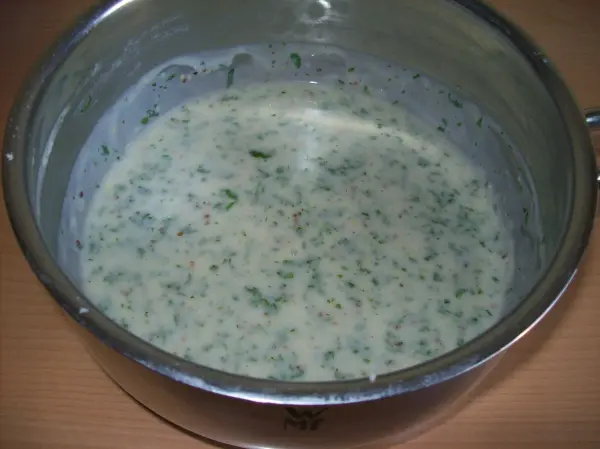 Frische Kräutersoße in einem Topf, cremig und grün, bereit zum Servieren mit gedünstetem Seelachs.
